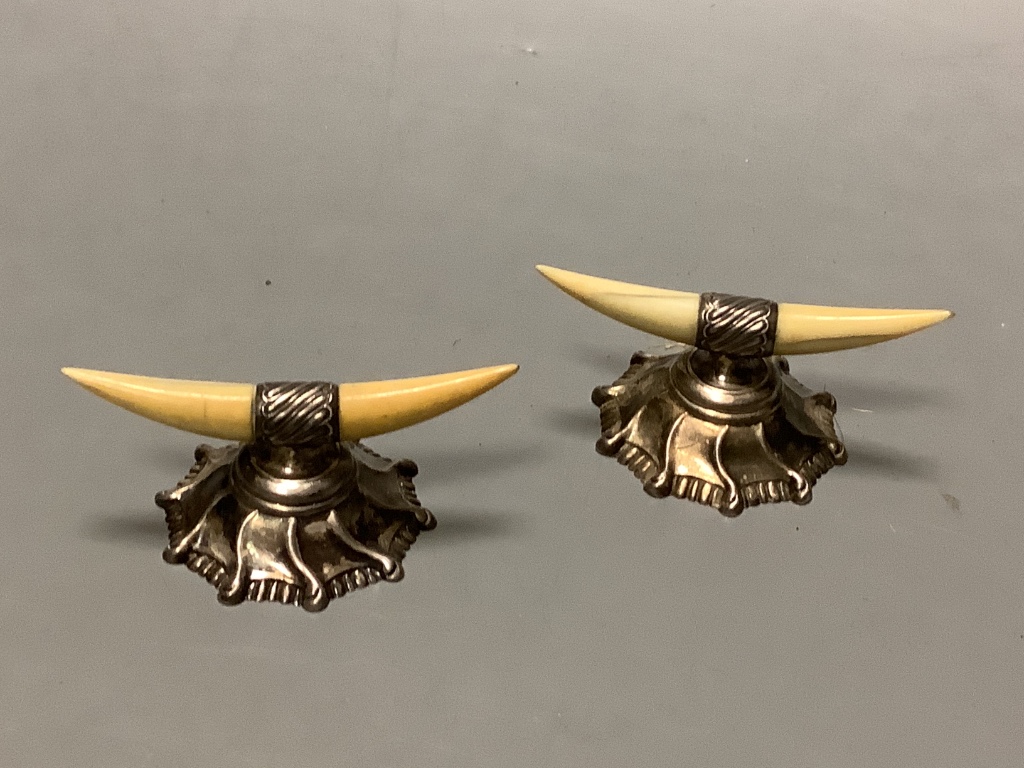 A set of four Edwardian engine turned silver napkin rings, Birmingham 1905, a pair of silver and Ivory mounted knife rests, a silver goblet and a silver dish.